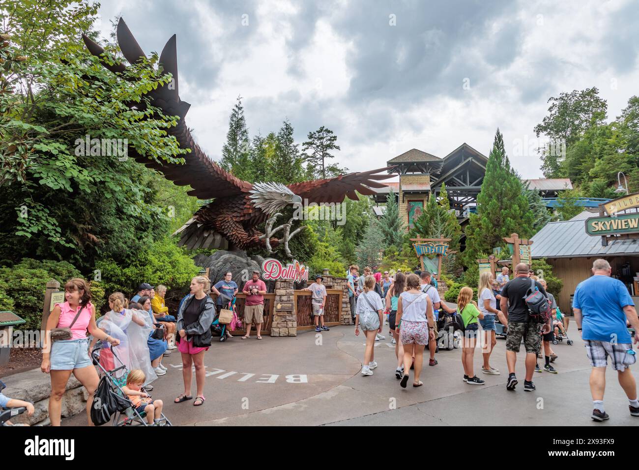 Parkgäste spazieren vorbei an einer großen Stahlskulptur eines Adlers in der Nähe der Achterbahn Wild Eagle Wing im Dollywood Vergnügungspark in Pigeon Forge Stockfoto