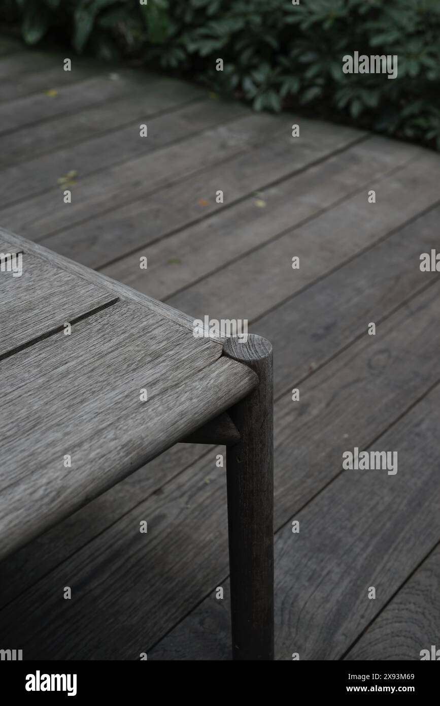 Grauer neutraler Tisch im Außenbereich auf organischem Holzfußboden im ästhetischen Design. Stockfoto