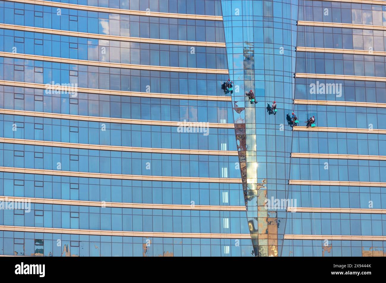 Baku. Aserbaidschan. 09.27.2021. Leute an hängenden Kabeln waschen die Fenster des Hotels. Stockfoto
