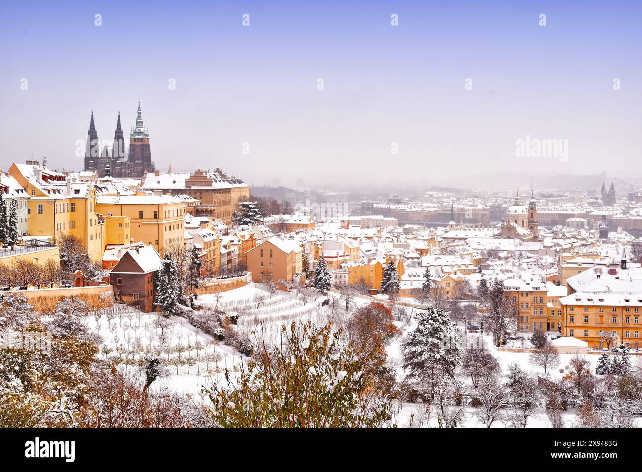 Schnee in Prag, seltene kalte Winterbedingungen. Prager Burg in Tschechien, schneebedecktes Wetter mit Bäumen. Stadtlandschaft aus der wunderschönen Stadt. Wintertra Stockfoto