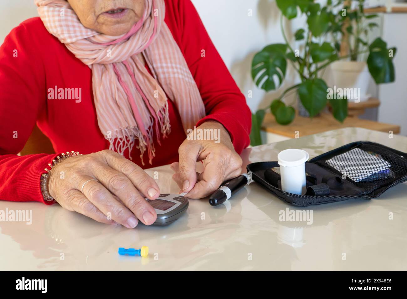 Patient mit Diabetes, der ein häusliches Kit zur Kontrolle des Blutzuckerspiegels zu Hause anfasst Stockfoto