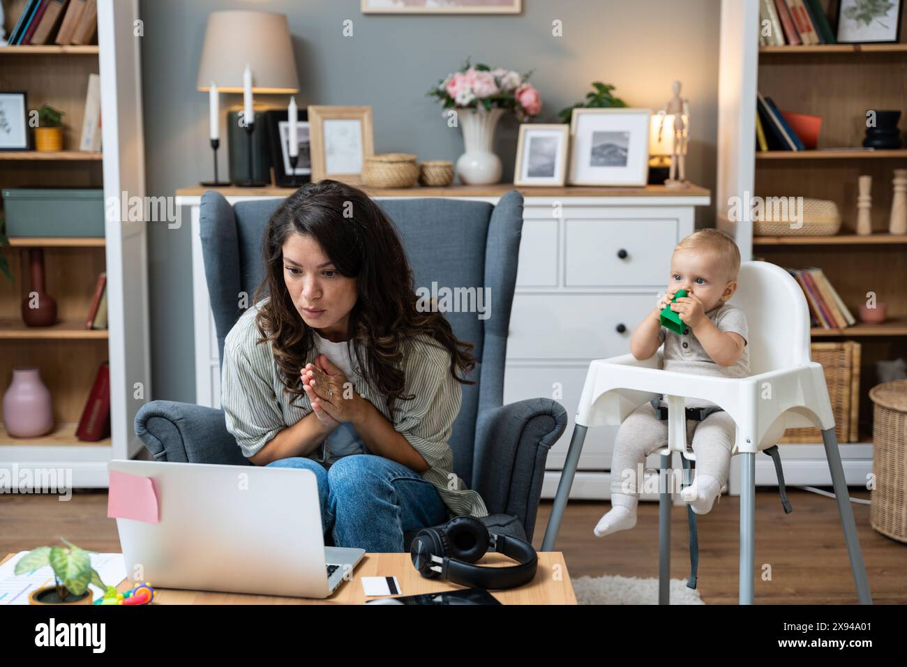 Junge alleinerziehende, geschiedene Mutter mit Baby, die einen Laptop für Videoanrufe mit ihrem Anwalt benutzte und über einen Ex-Ehemann sprach, der keine Unterhaltszahlungen und keine Kosten zahlte Stockfoto