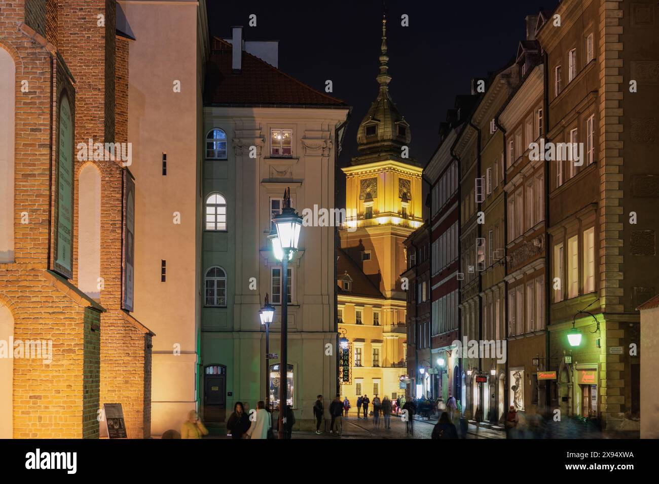 Flache Gebäude mit vorbeiziehender Menschenmenge in der Nähe des Schlossplatzes (Plac Zamkowy), der historischen Straße Swietojanska bei Nacht, der Altstadt, Warschau, Polen, Europa Stockfoto