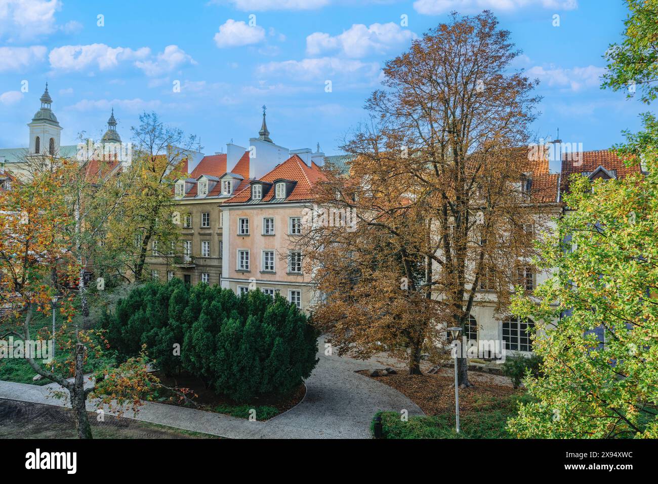 Blick auf traditionelle Flachdachhäuser hinter einem Park unter blauem Himmel mit Wolken, Warschau, Polen, Europa Stockfoto