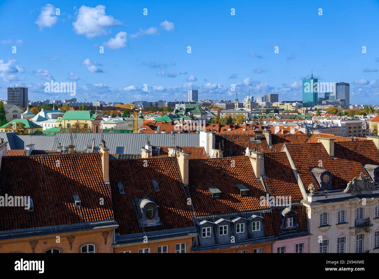 Panoramablick auf die Skyline der Stadt mit traditionellen Flachdachhäusern und modernen Wolkenkratzern unter blauem Himmel mit Wolken, Warschau, Polen, Europa Stockfoto