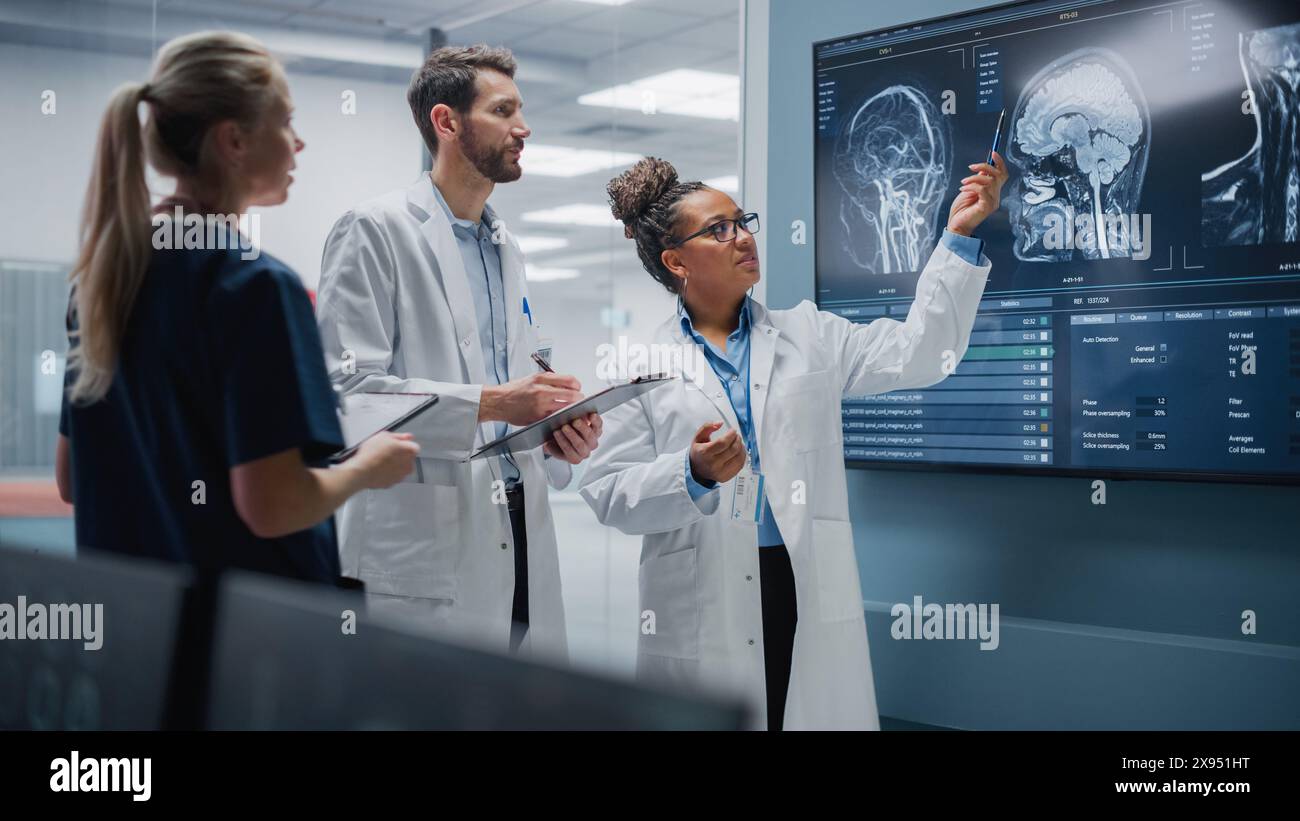 Medical Science Hospital Lab Meeting: Diverse Team von Neurologen, Neurowissenschaftlern, Neurochirurgen konsultieren TV Bildschirm zeigen MRT-Scan mit Gehirnbildern, sprechen über Behandlungsmethode, neue Medikamente Heilung Stockfoto