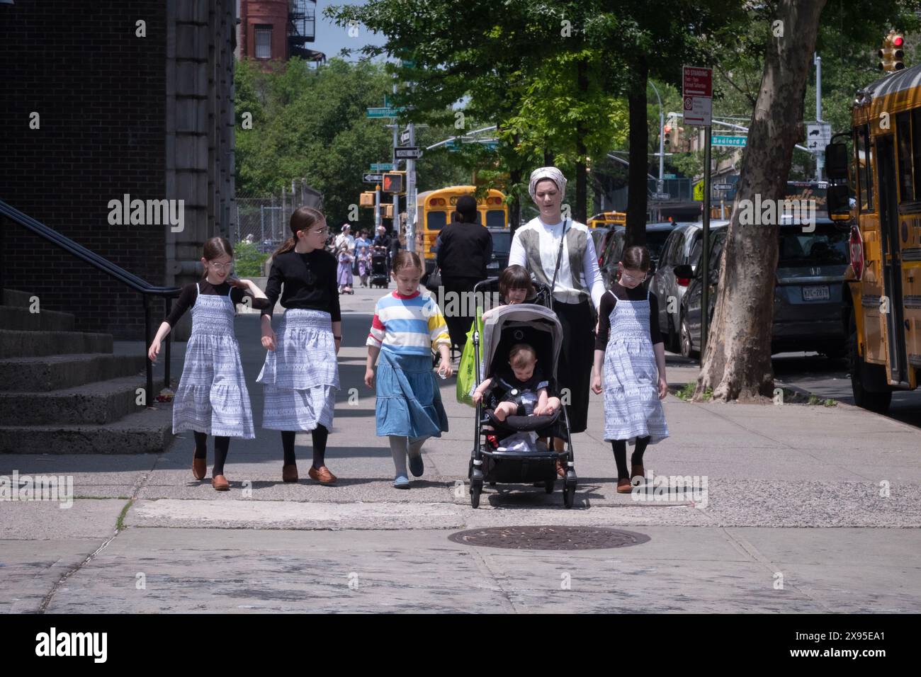 Eine orthodoxe jüdische Mutter und ihre sechs Kinder laufen auf der Bedford Avenue in Williamsburg, Brooklyn, New York. Stockfoto