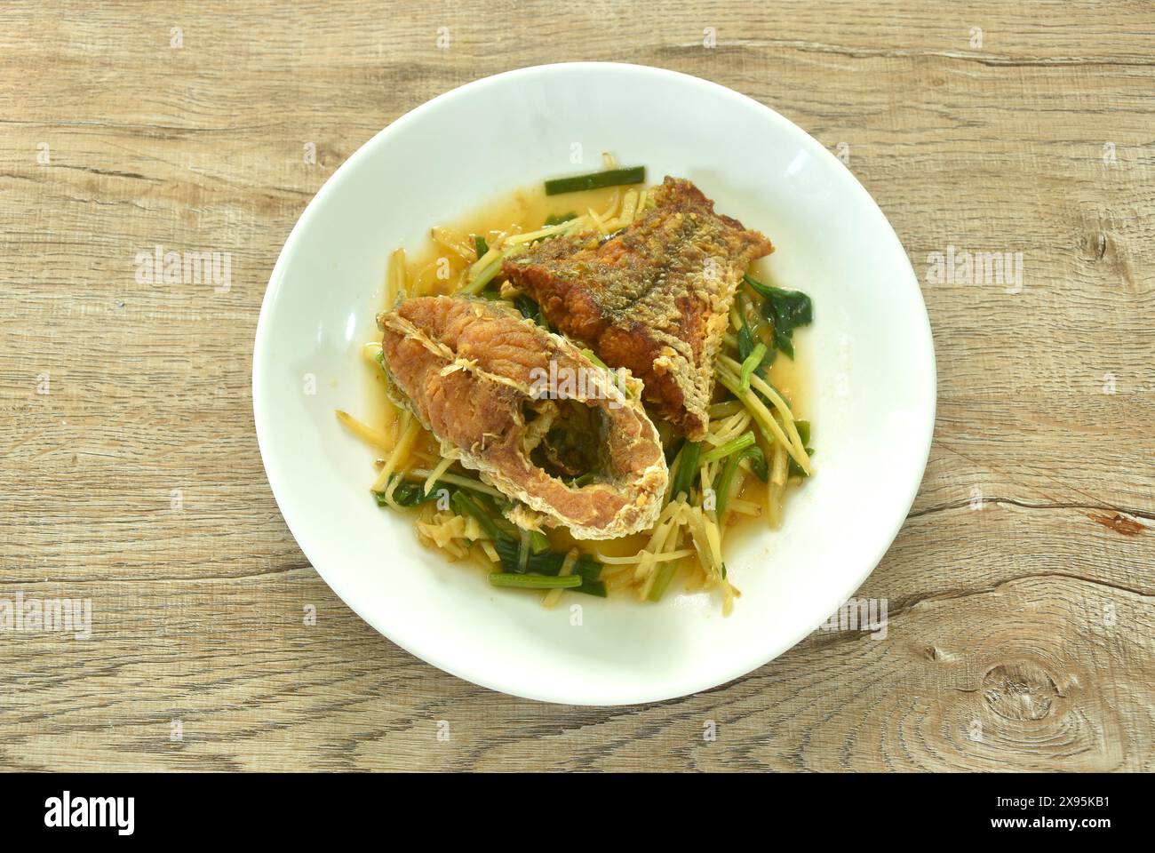 Frittierte, gehackte rote Barschfische in Scheiben, Sojasoße und Sellerie auf dem Teller Stockfoto
