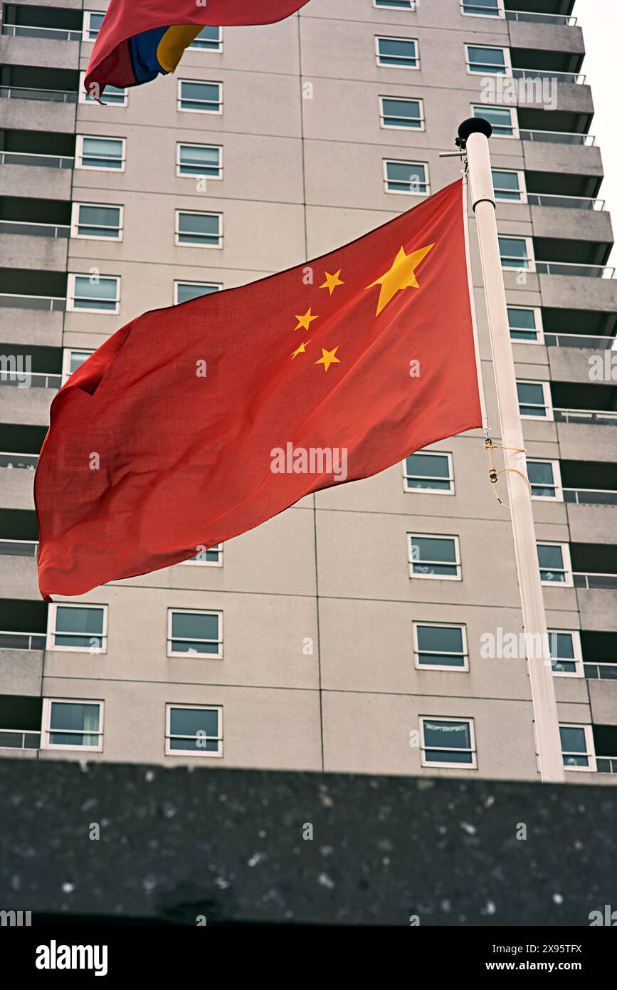 Gebäude, Wind und Flagge von China auf Pole für Land, Kongress und nationale Banner der Identität. Material, Farbe und Zustand-Gewebe mit Welle für Stockfoto