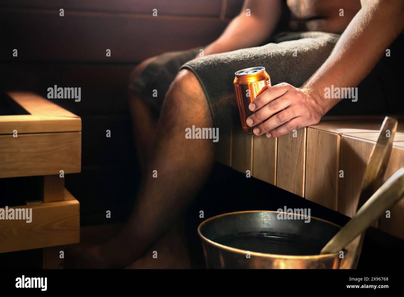 Sauna und Bier. Mann im Dampfbad entspannt und trinkt etwas. Traditionelles finnisches Wellnesszentrum aus dunklem Holz oder im Wellness-Hotel in Finnland. Stockfoto