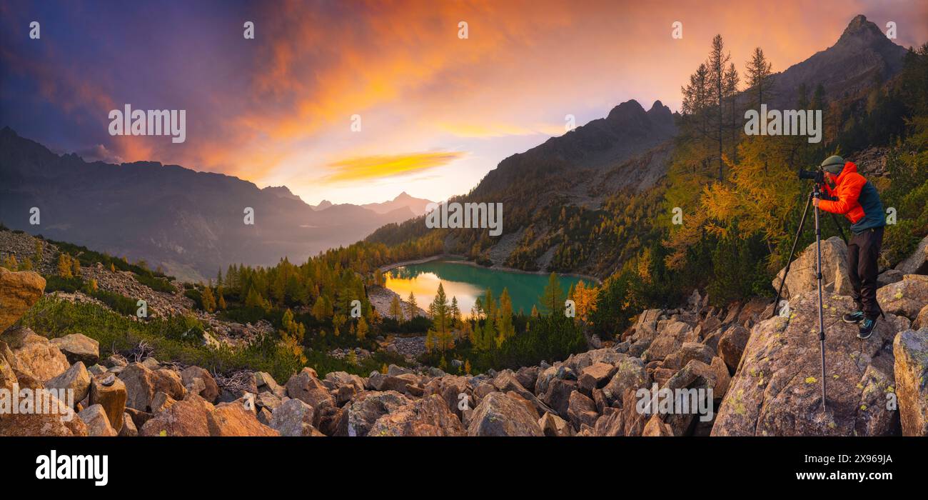 Panoramablick auf einen Fotografen am See Lagazzuolo bei Sonnenaufgang im Herbst, Chiesa di Valmalenco, Sondrio, Italien, Europa Stockfoto