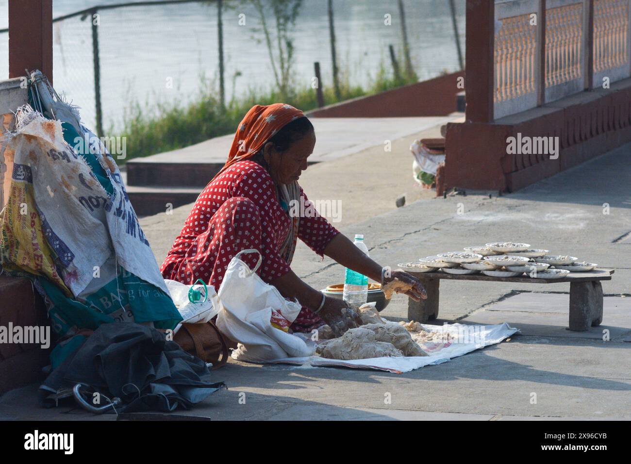 Ein Bild einer traditionellen Rajasthani Straßenverkäuferin, die Fischfutter verkauft. Stockfoto