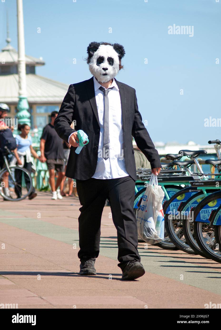 Ein Mann trägt eine Pandabärenmaske an der Küste von Brighton Stockfoto