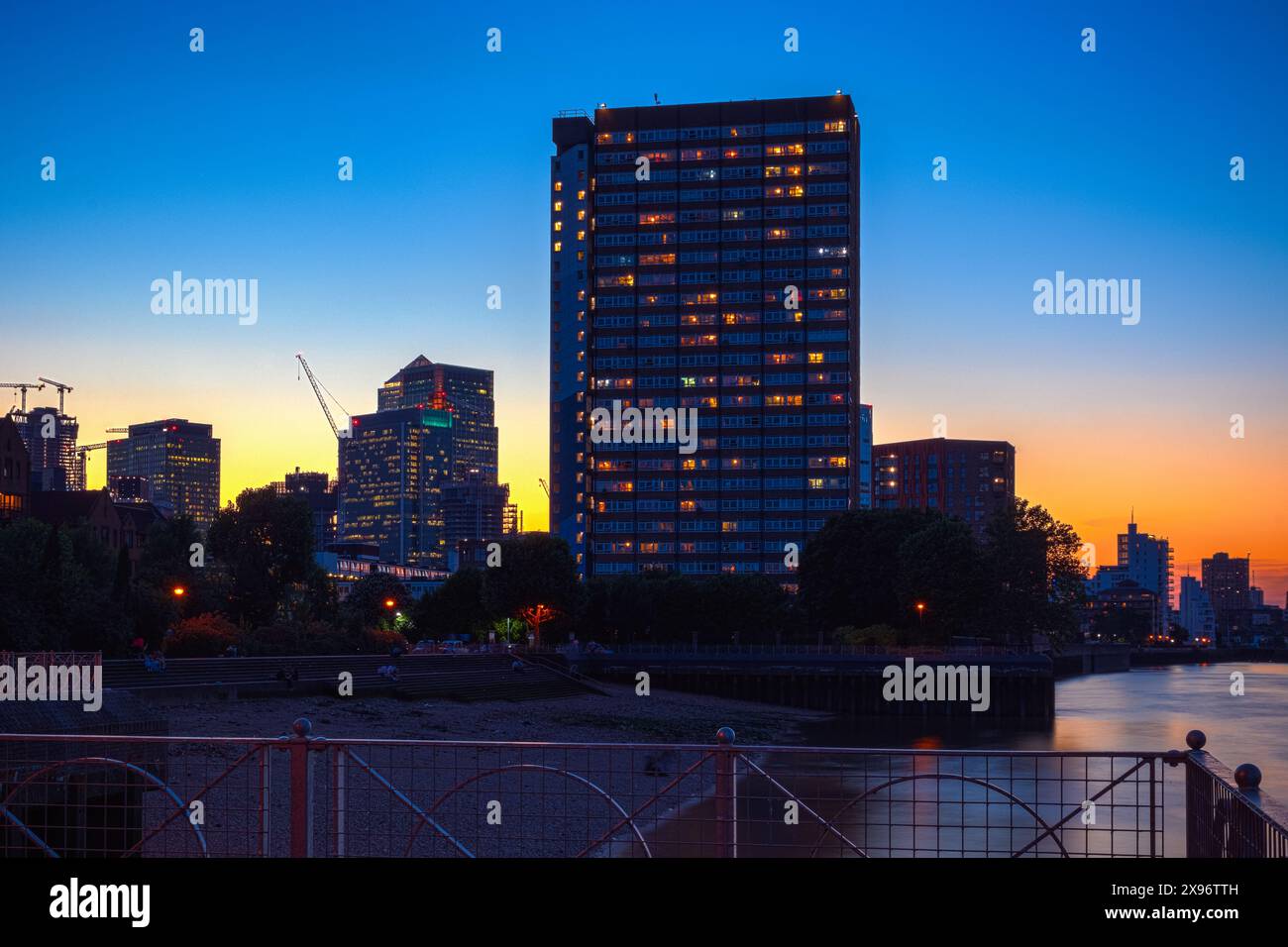 Riverside Tower Block Kelson House in Samuda Estate bei Sonnenuntergang mit Canary Wharf im Hintergrund Stockfoto