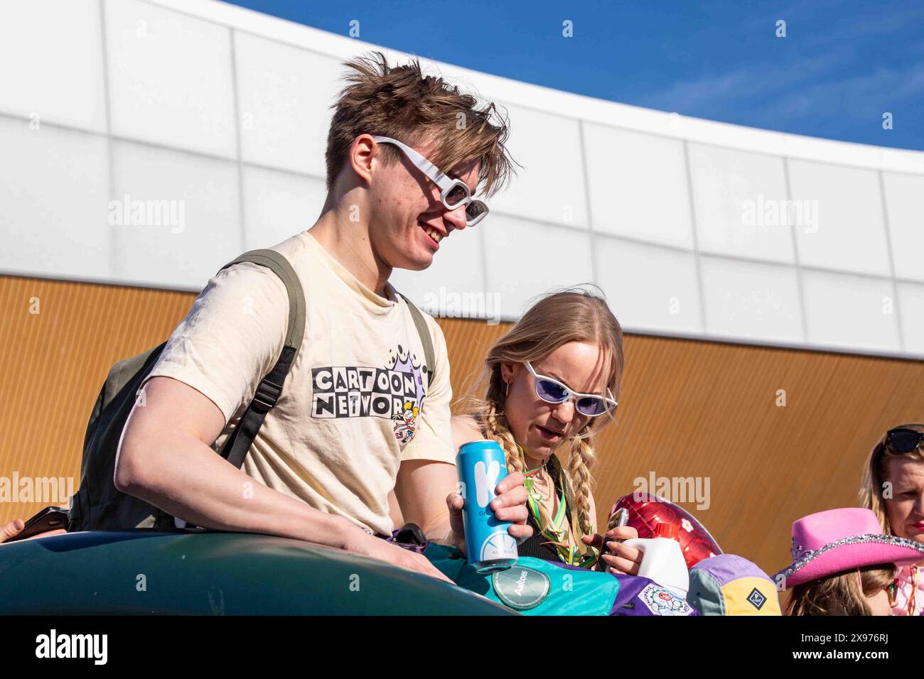 Studentin mit Cartoon Network T-Shirt und weißer Sonnenbrille, die am 1. Mai von der Oodi Library in Helsinki, Finnland, feiert Stockfoto