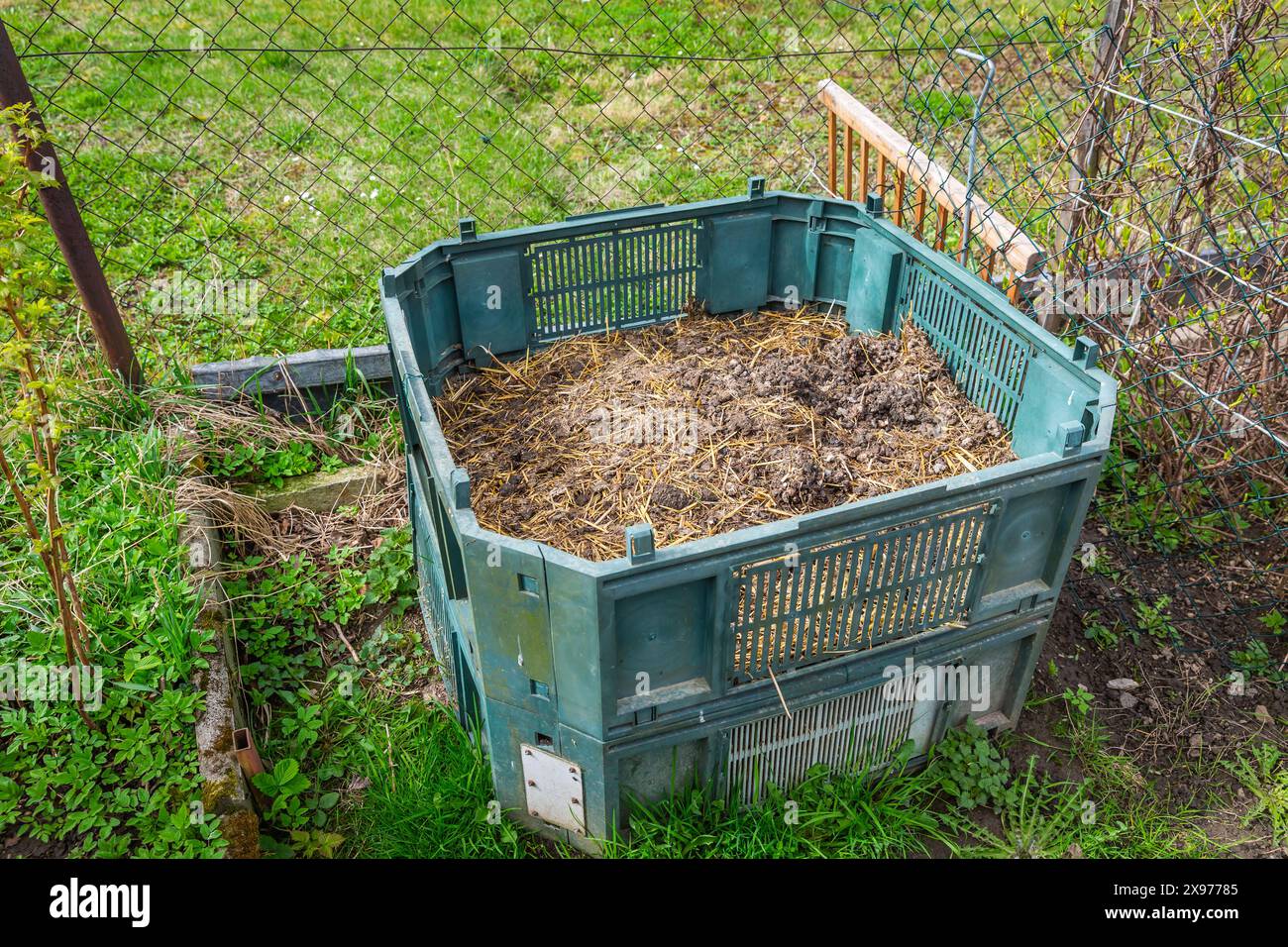 Kompostbehälter in einem Garten, in dem Küche und Grünabfälle zur Herstellung von organischem Dünger verwendet werden Stockfoto