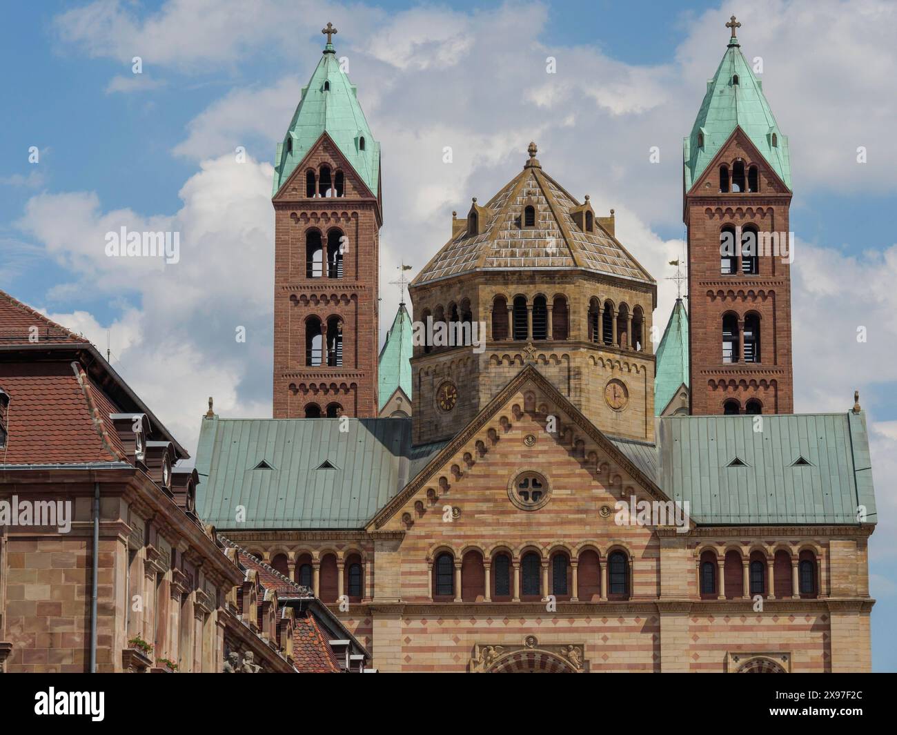 Detaillierte Aufnahme einer historischen Kirche mit grünen Türmen und blauem Himmel im Hintergrund, große Kathedrale mit zwei Türmen vor blauem Himmel mit Stockfoto