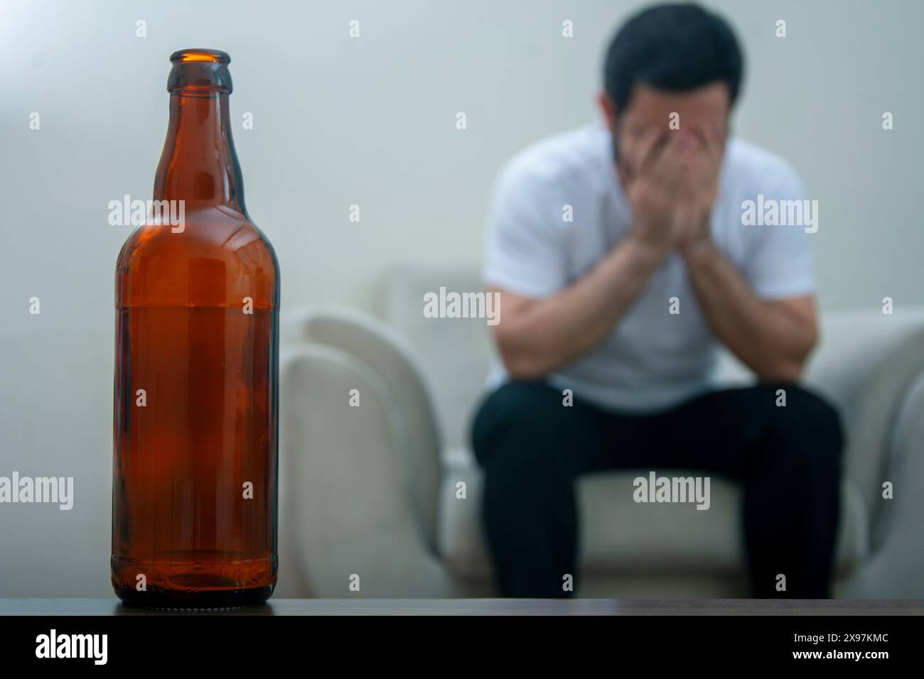 Alkoholischer Mann bereut den nächsten Tag Nahaufnahme mit Trinkflasche Stockfoto