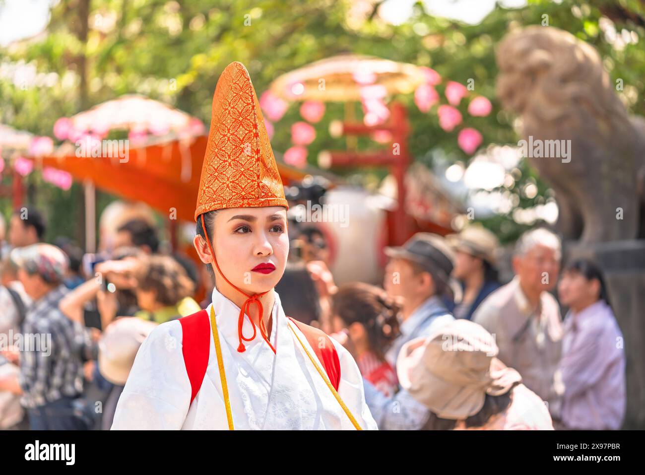 tokio, asakusa - 17. Mai 2024: Ein Büstenporträt einer japanischen Dame in weißer Reihentänzerkleidung mit traditionellem, gesticktem eboshi-Hut besticht durch seine Bande Stockfoto