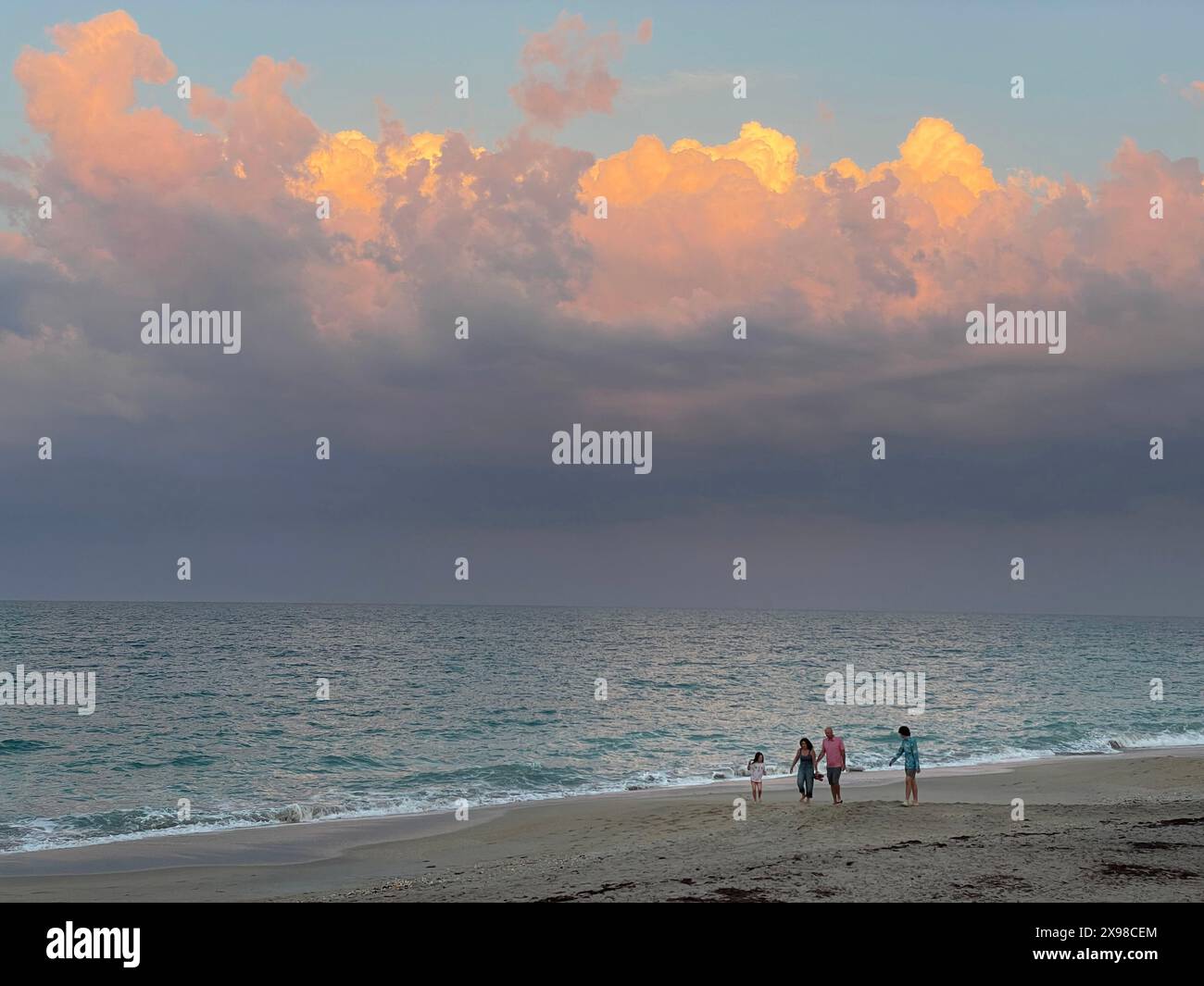 Eine Familie spaziert am Strand bei Sonnenuntergang am Vero Beach, Florida, USA Stockfoto