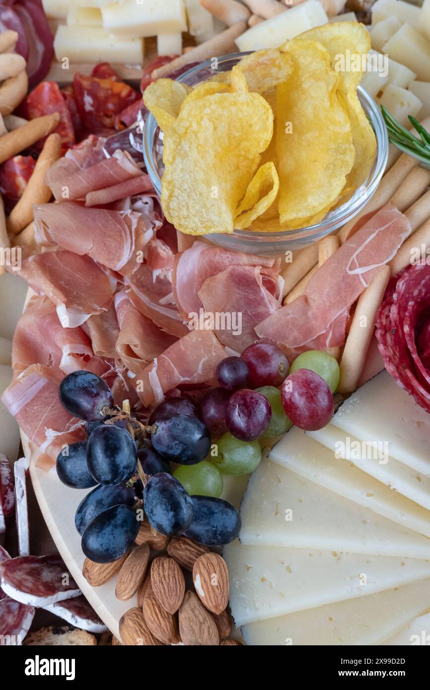 Köstliche Auswahl an herzhaften Tapas auf einer Wurstplatte für ein gemeinsames kulinarisches Erlebnis, Präsentation von Wurstwaren wie serrano-Schinken und Chorizos Stockfoto
