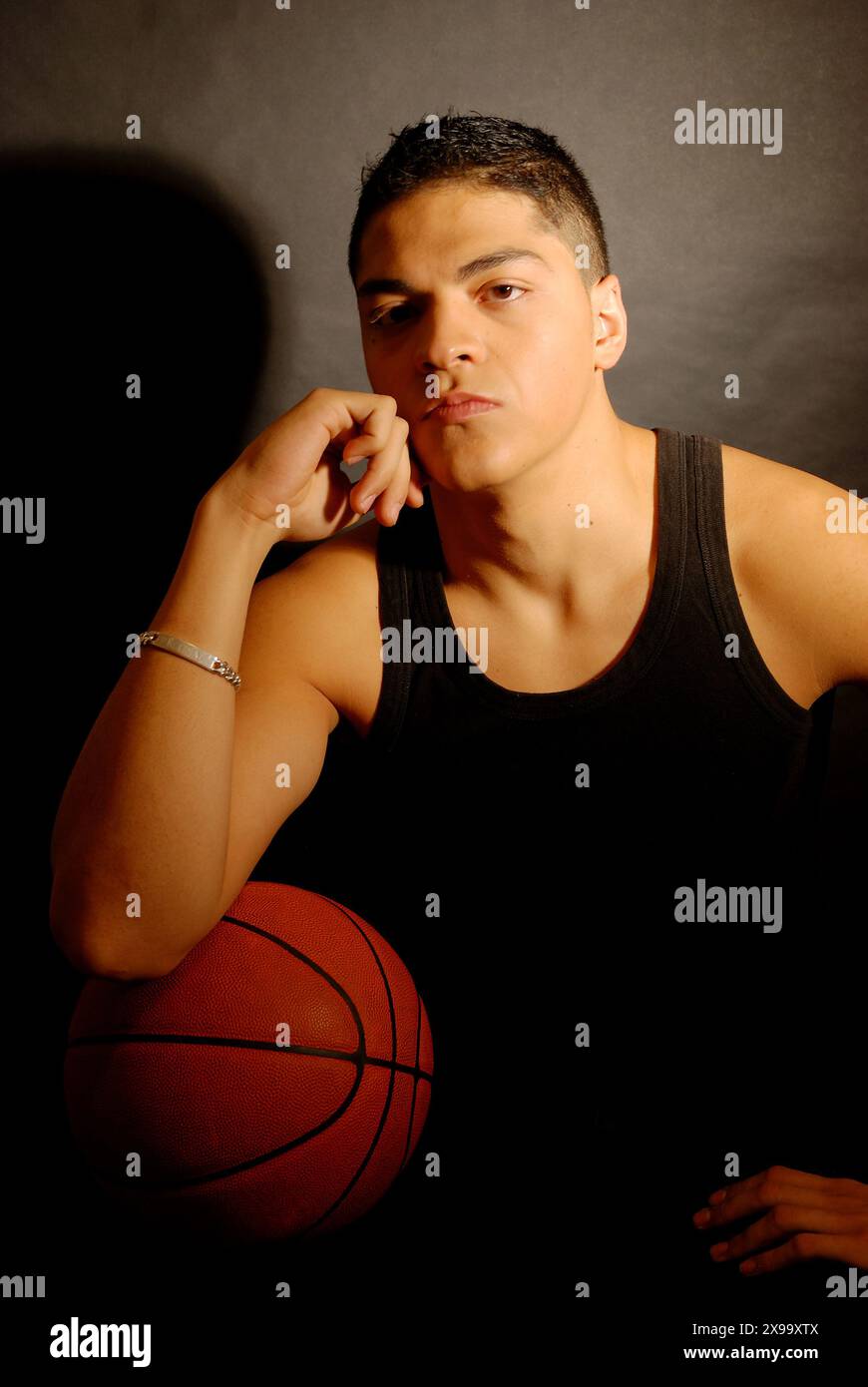 Porträt eines jungen Mannes mit Basketball, der in die Kamera blickt. Stockfoto