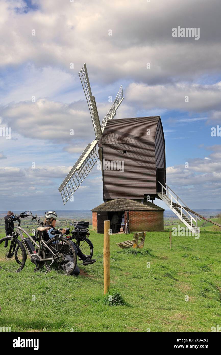 Brill Post Mill Windmill in Buckinghamshire, Großbritannien, mit Radfahrern auf einer Bank Stockfoto