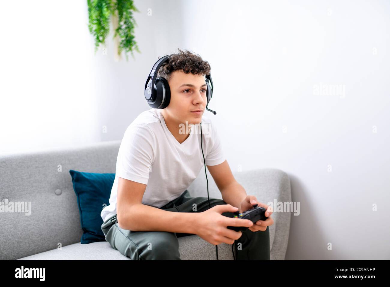 Porträt eines Teenagers, der im Urlaub Videospiele im fernsehen spielt, sitzt zu Hause auf der gemütlichen Couch Stockfoto Porträt eines Teenagers, der im Urlaub Videospiele im fernsehen spielt, sitzt zu Hause auf der gemütlichen Couch Stockfoto