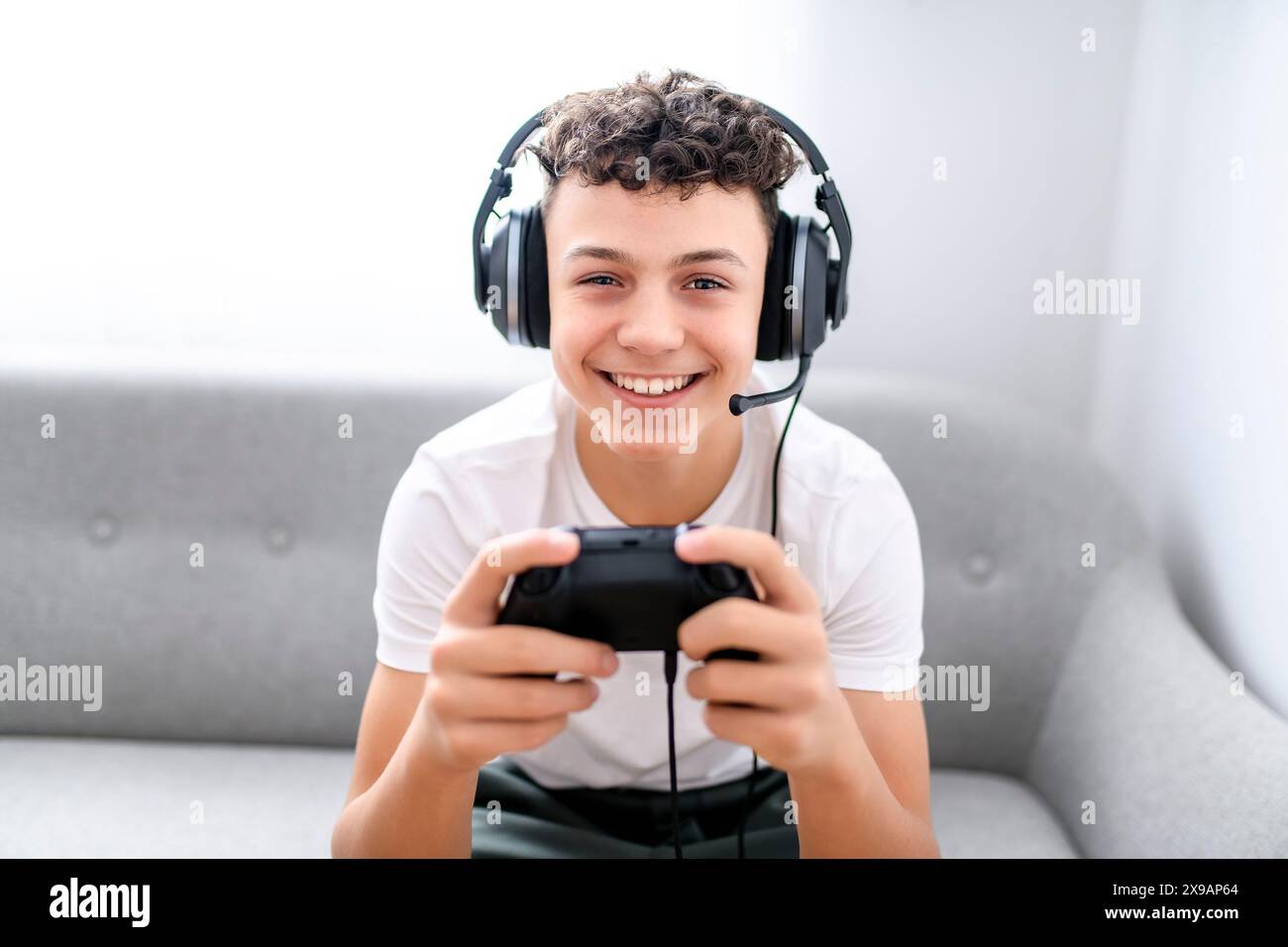 Porträt eines Teenagers, der im Urlaub Videospiele im fernsehen spielt, sitzt zu Hause auf der gemütlichen Couch Stockfoto Porträt eines Teenagers, der im Urlaub Videospiele im fernsehen spielt, sitzt zu Hause auf der gemütlichen Couch Stockfoto