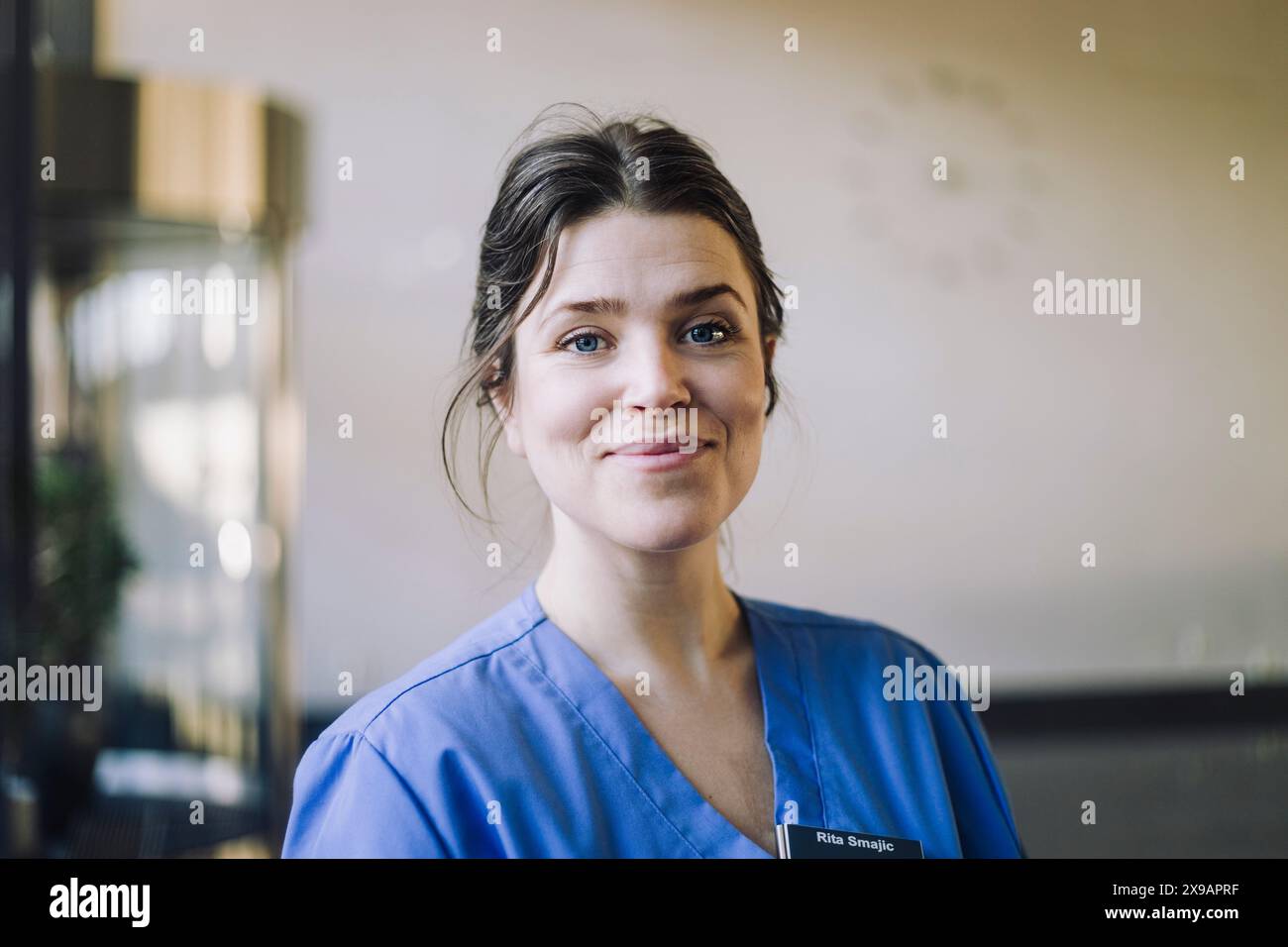 Porträt einer lächelnden Ärztin in blauen Schutten im Krankenhaus Stockfoto