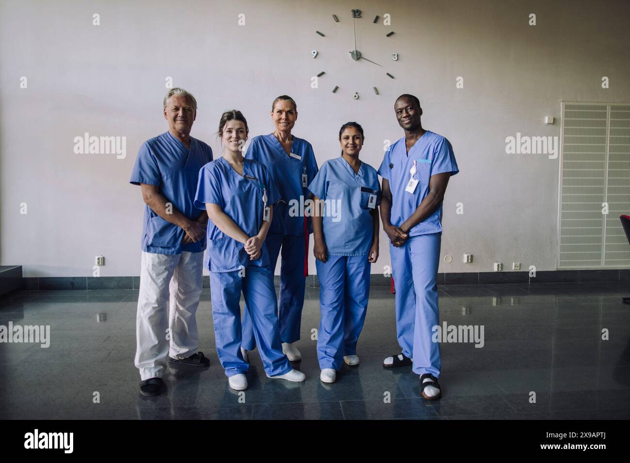 Porträt in voller Länge von vertrauensvollen, vielfältigen medizinischen Fachkräften, die im Krankenhaus zusammen stehen Stockfoto