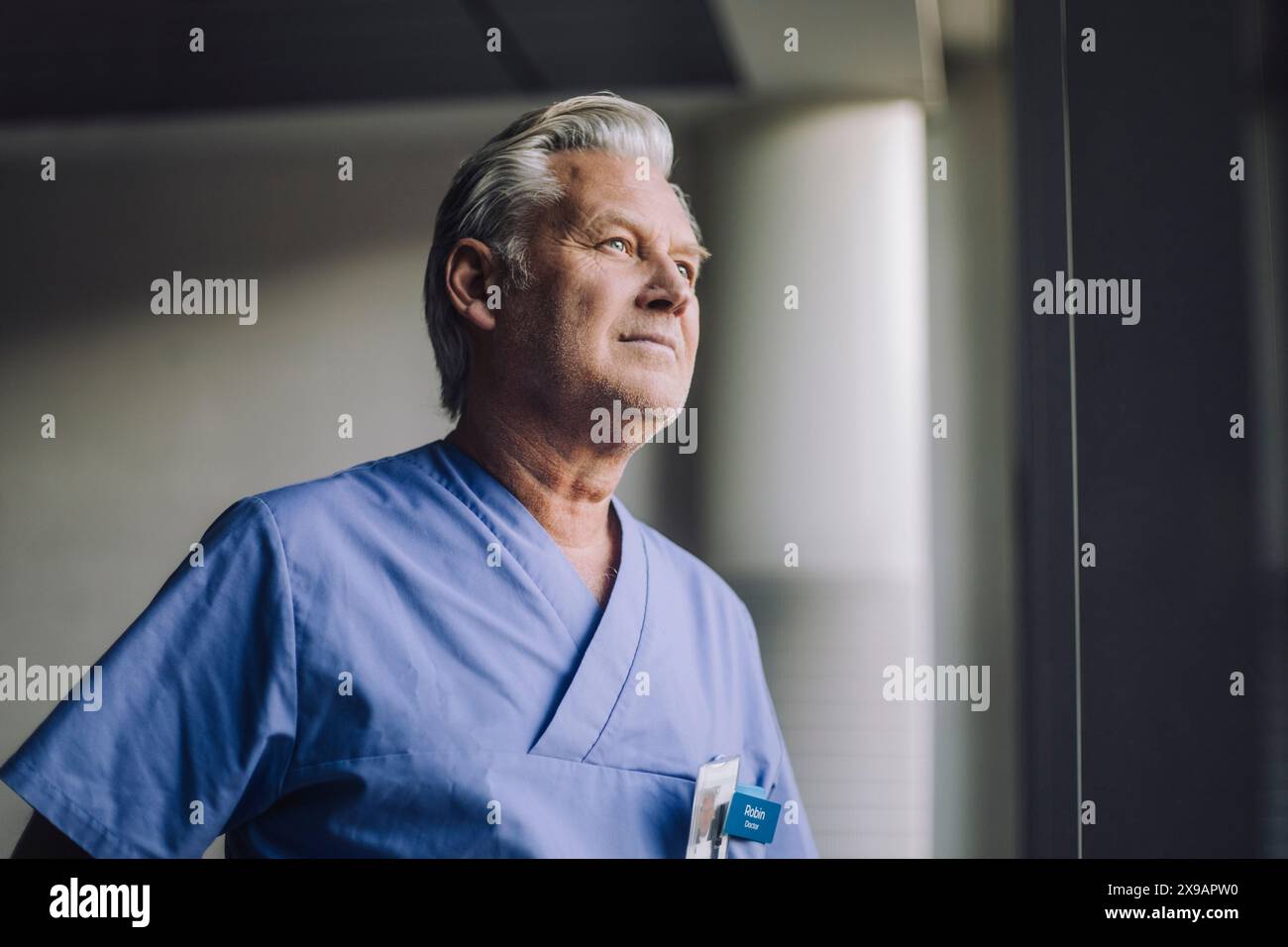 Nachdenklicher Oberarzt in blauen Peelings im Krankenhaus Stockfoto