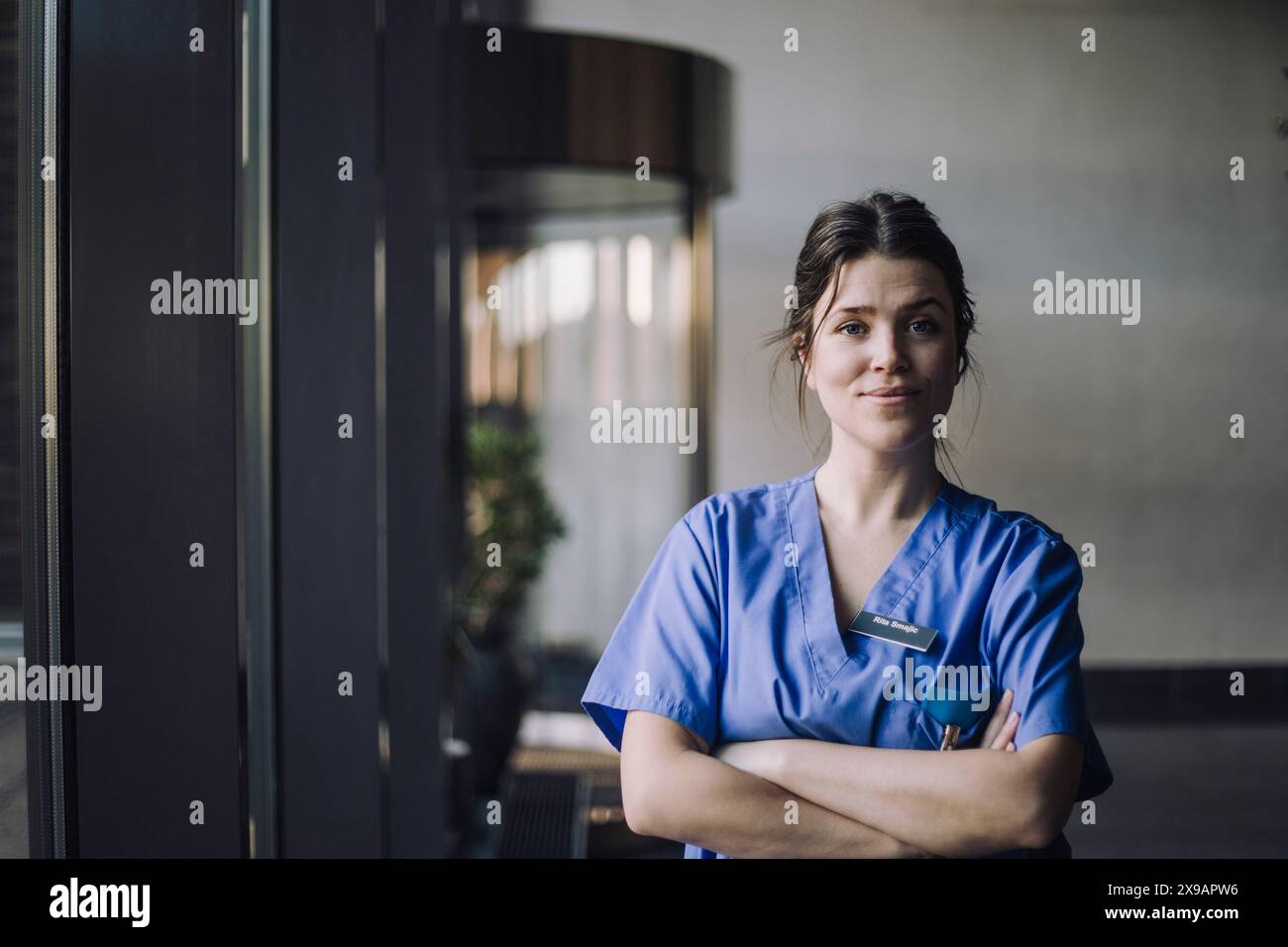 Porträt einer selbstbewussten Ärztin in blauen Peelings, die im Krankenhaus steht Stockfoto