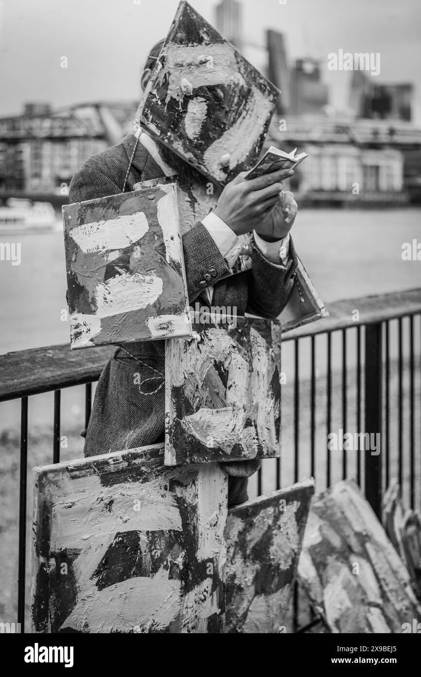 Ein Schwarzweiß-Bild eines Mannes mit Kunstwerken auf der South Bank in London. Stockfoto