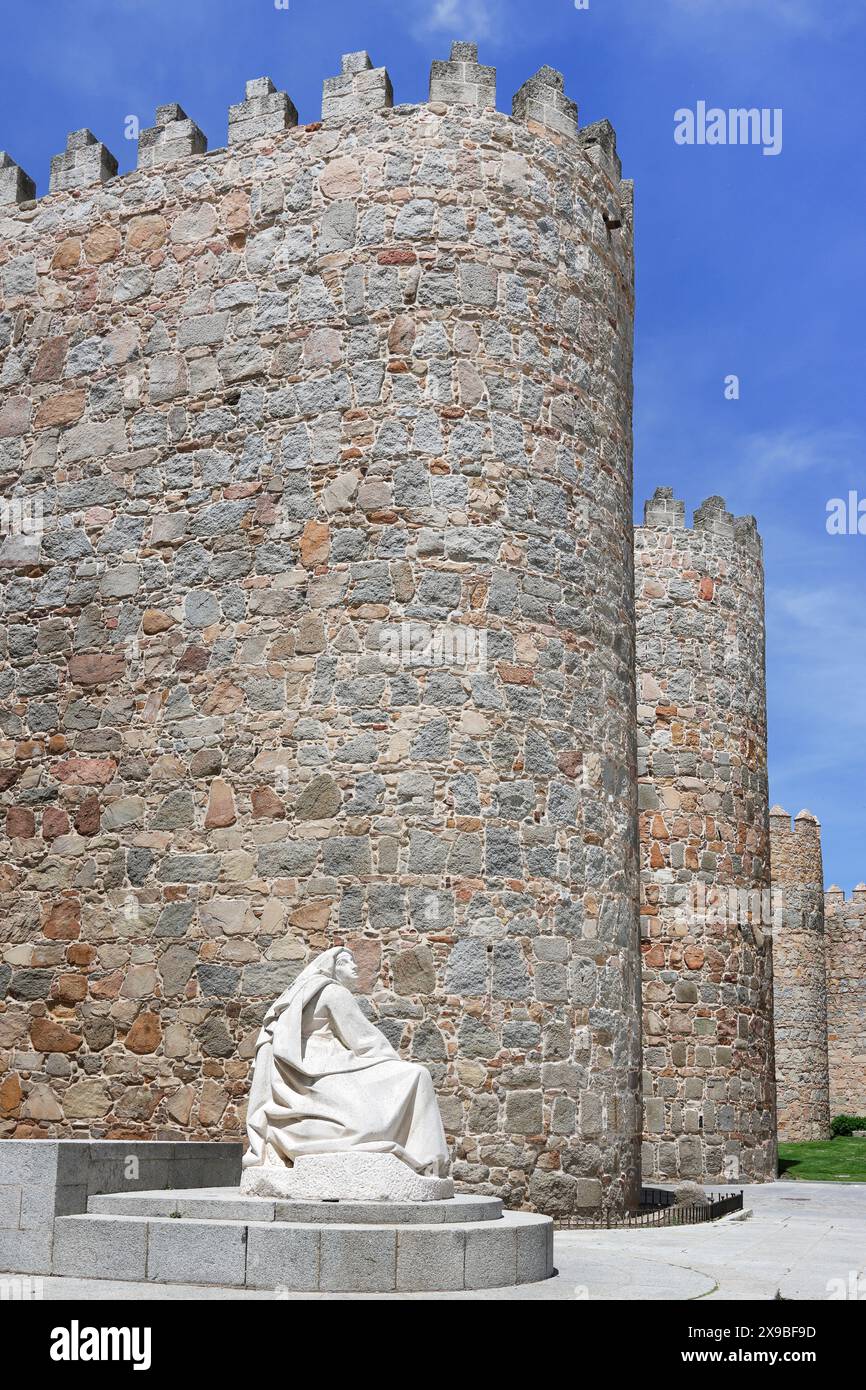 Statue der Heiligen Theresia von Avila, mit mittelalterlichen Mauern im Hintergrund Stockfoto