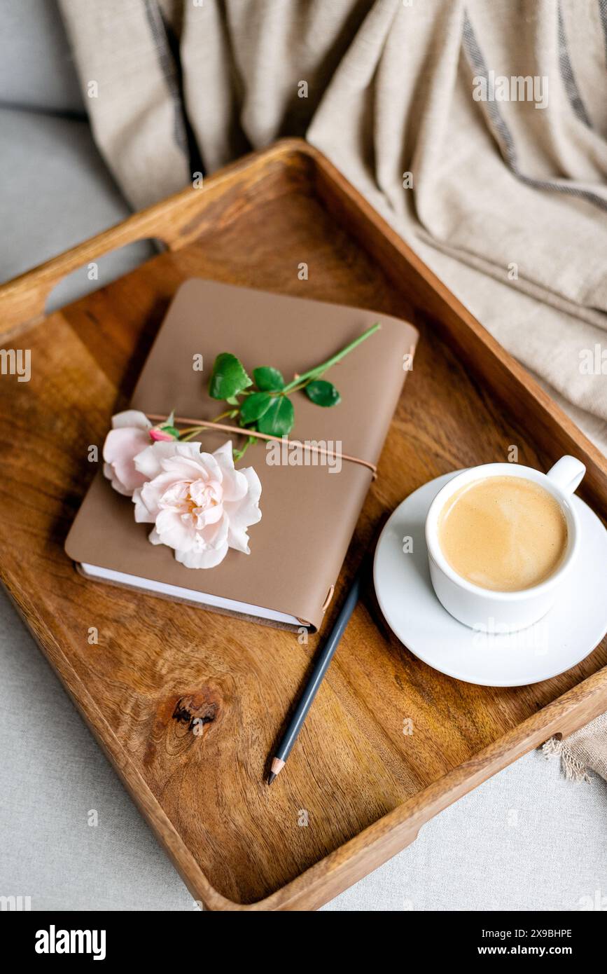 Notizblock, Bleistift und eine Tasse Kaffee auf einem Tablett Stockfoto