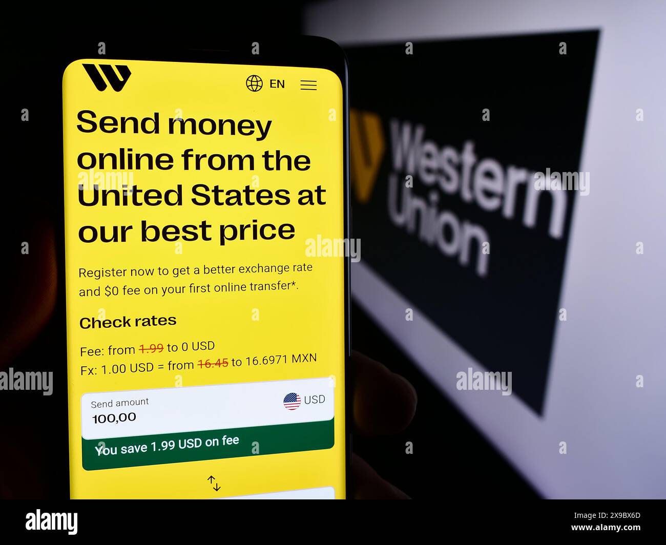 Person mit Smartphone und Webseite des US-Finanzdienstleistungsgeschäfts The Western Union Company mit Logo. Konzentrieren Sie sich auf die Mitte des Telefondisplays. Stockfoto