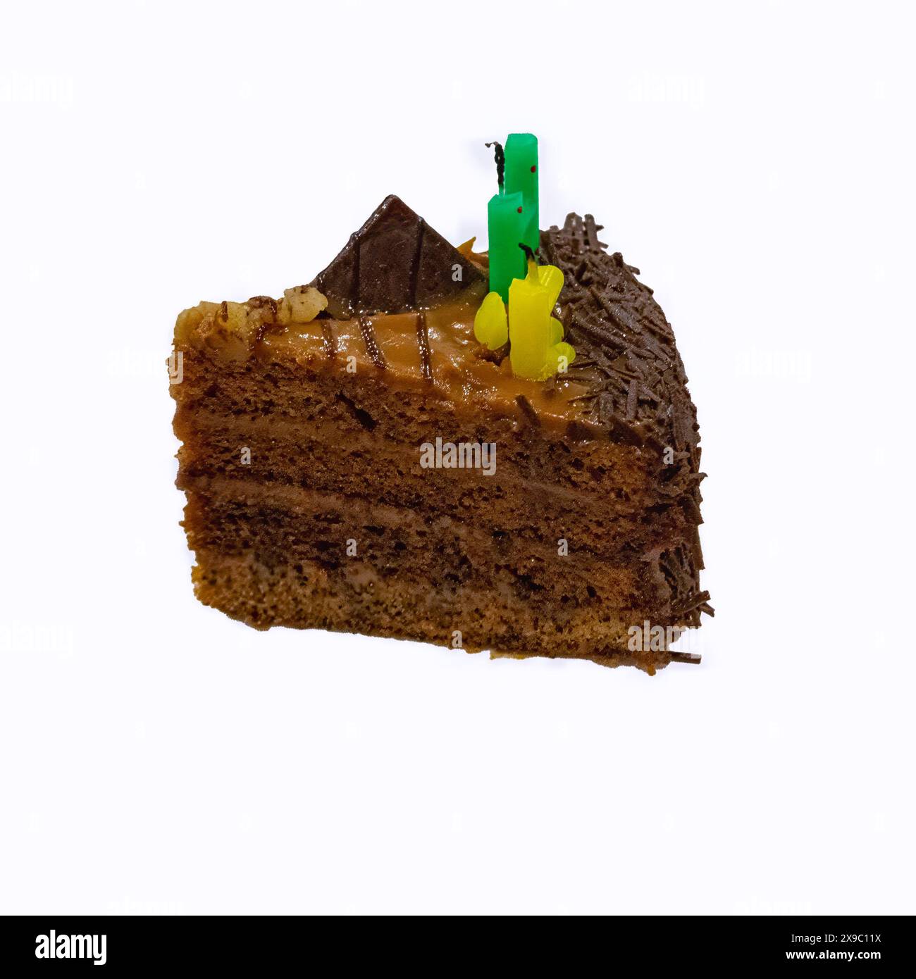 Ein Stück Schokoladenkuchen mit Buttercreme und erloschenen Kerzen isoliert auf weißem Hintergrund. Stockfoto