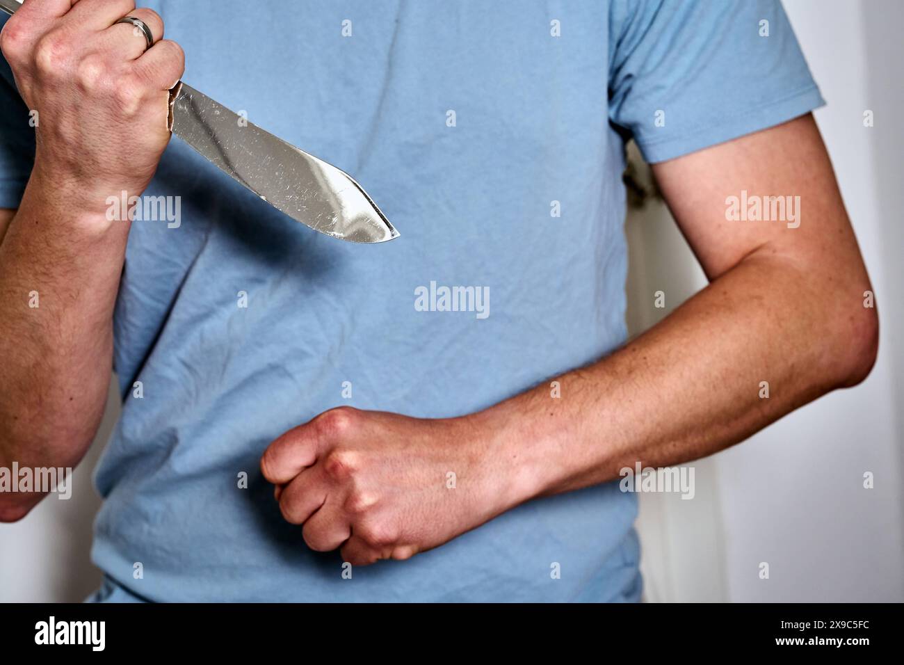 30. Mai 2024: Symbolisches Bild häuslicher Gewalt. Ein wütender Mann hält ein Messer in der Hand und ballt seine Faust *** Symbolbild häusliche Gewalt. Ein wütender Mann hält ein Messer in der Hand und Ball die Faust zusammen Stockfoto