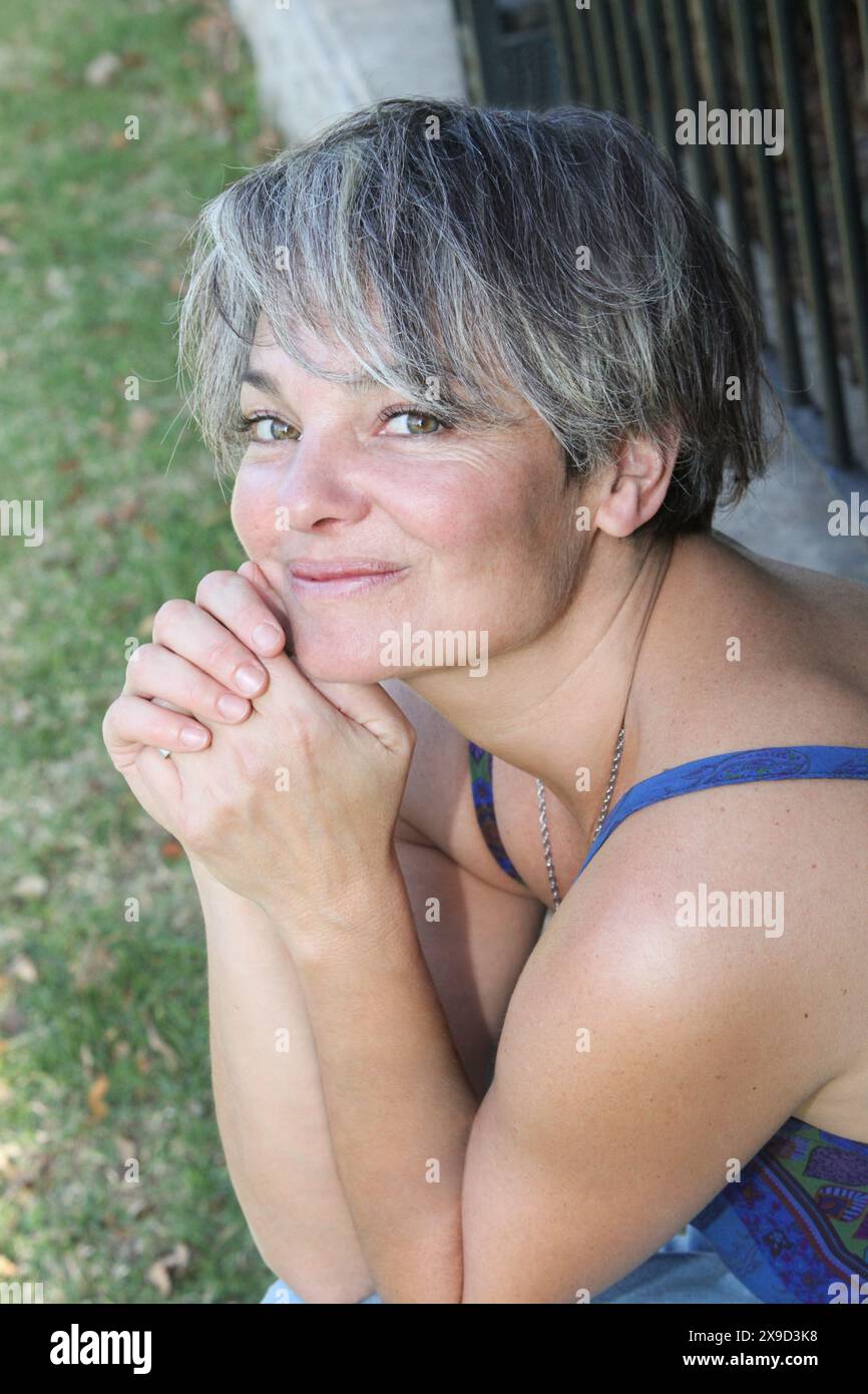 Porträt einer Frau mittleren Alters, die sich im Freien erholt Stockfoto