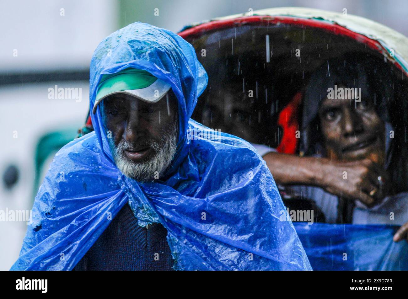 Fußgänger, die durch überflutete Straßen in Sylhet wegen Zyklon Remal navigieren. In den letzten Tagen im ganzen Land haben starke Regenfälle stattgefunden, und die Küstengebiete haben erhebliche Schäden erlitten. Sylhet, Bangladesch. Stockfoto