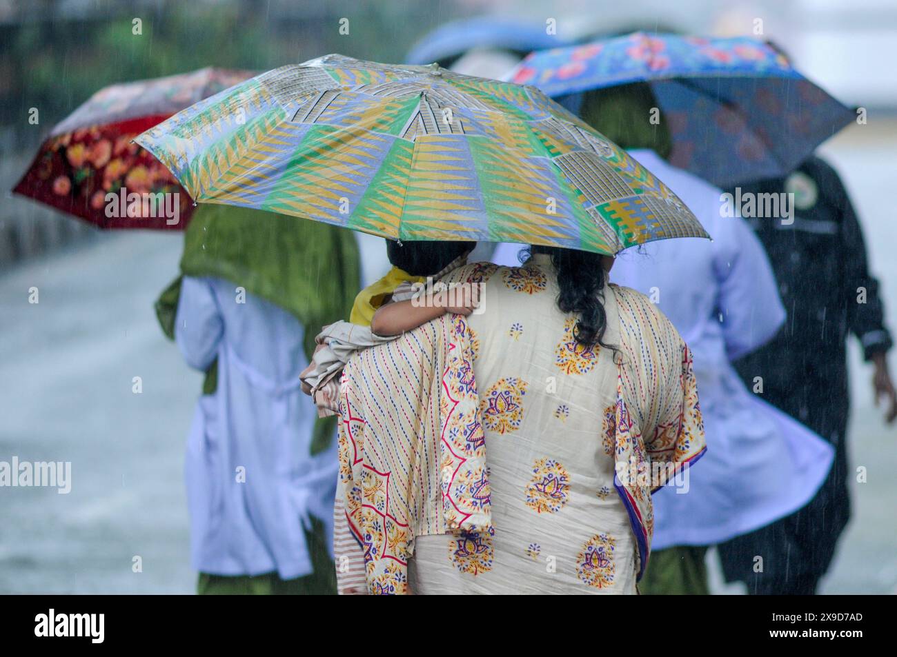 Fußgänger, die durch überflutete Straßen in Sylhet wegen Zyklon Remal navigieren. In den letzten Tagen im ganzen Land haben starke Regenfälle stattgefunden, und die Küstengebiete haben erhebliche Schäden erlitten. Sylhet, Bangladesch. Stockfoto