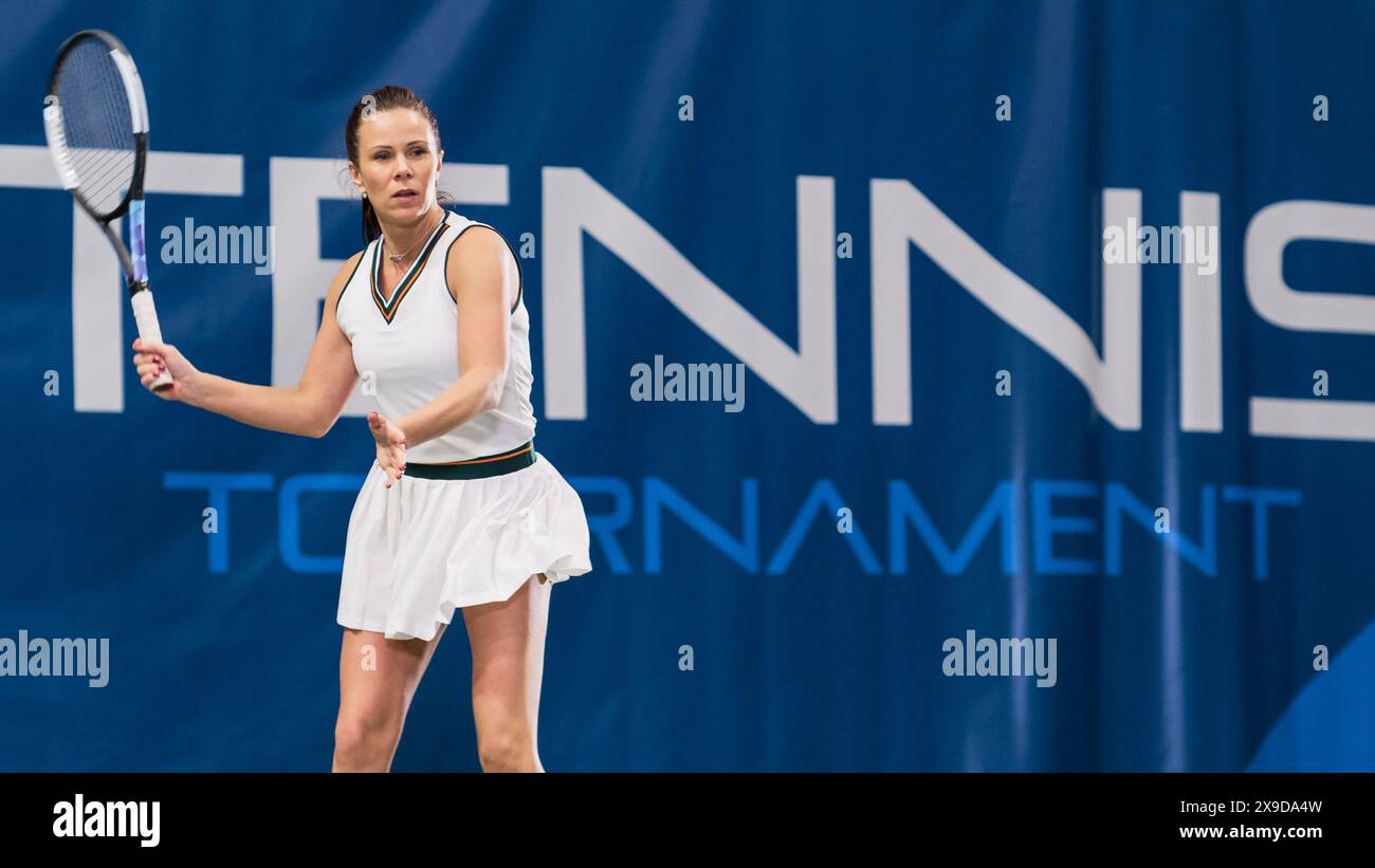 Tennisspielerin, die während des Meisterschaftsspiels einen Ball mit einem Racquet anstrebt. Profi-Athletin wird gleich einen perfekten Rückhandschuss erhalten. World Sports Tournament Konzept. Stockfoto