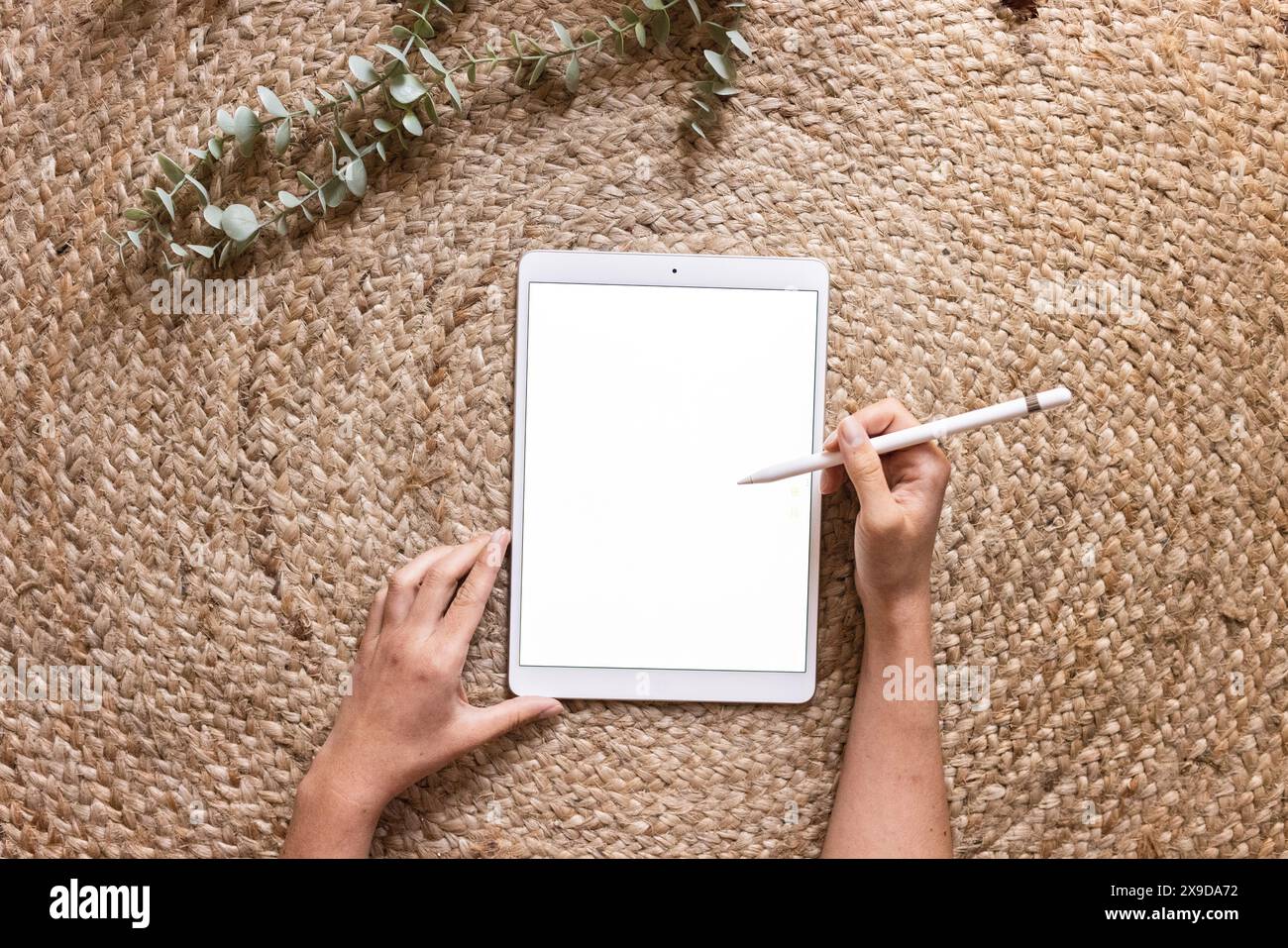 Frauenhände mit einem weißen Tablet und einem Stift mit einem Kopierraum, um Text oder eine App hinzuzufügen. Stockfoto