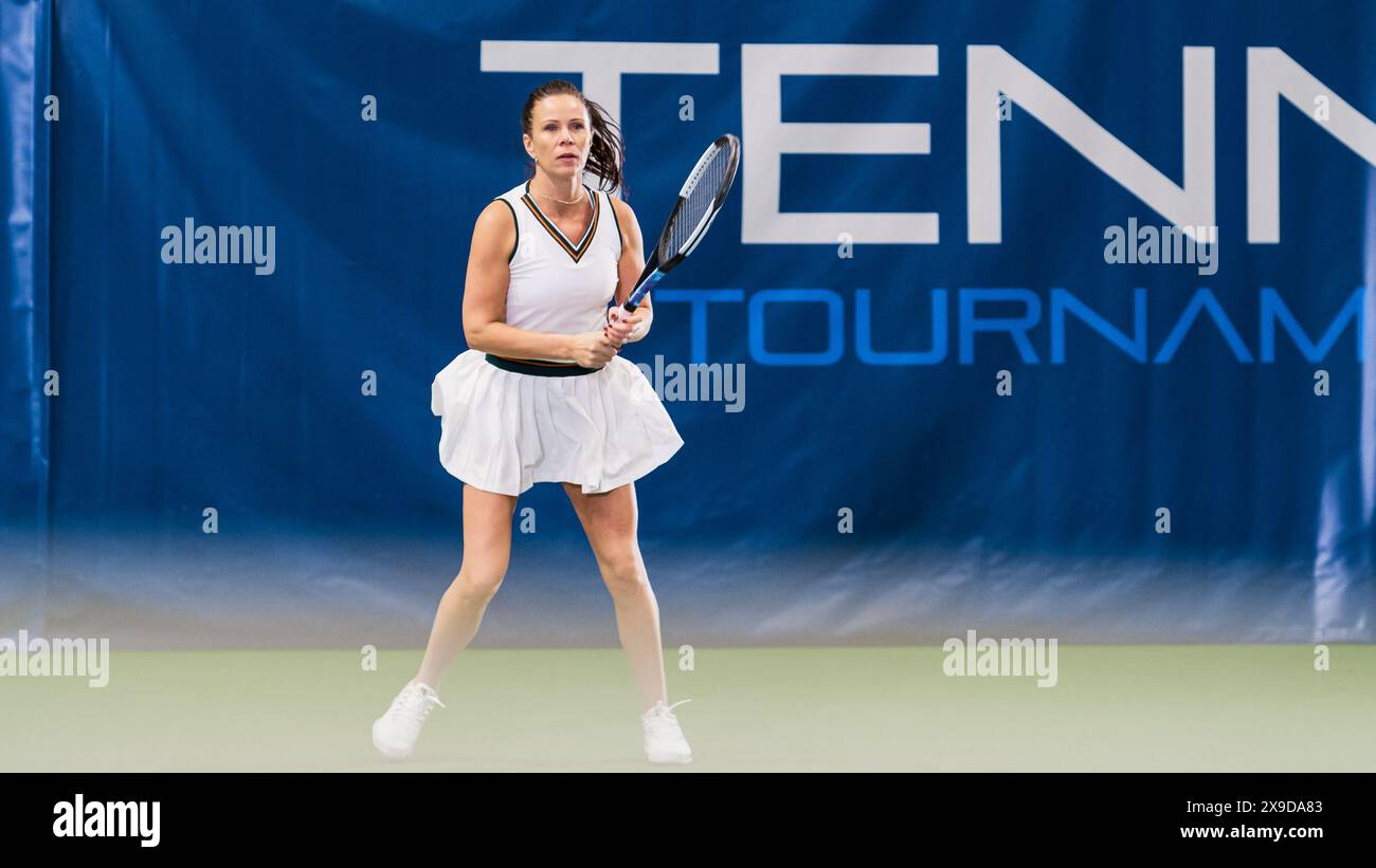 Tennisspielerin wartet auf Ball mit einem Racquet in den Händen während des Meisterschaftsspiels. Profi-Athletin erhält und landet perfekten Rückhandschuss. World Sports Tournament Konzept. Stockfoto