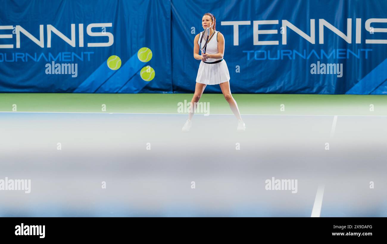 Tennisspielerin, die während des Meisterschaftsspiels Ball mit einem Racquet ansieht. Die Technikerin Athlete erhält und landet den perfekten Volley-Schuss. World Sports Tournament Konzept. Weitwinkelfoto. Stockfoto