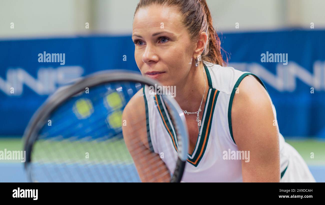 Potrait der Tennisspielerin, die während des Meisterschaftsspiels den Racquet hält, bereit für den Ball Strike. Selbstbewusste Leistungssportlerin. Konzentriere dich auf das Gesicht der Sportlerin. Stockfoto
