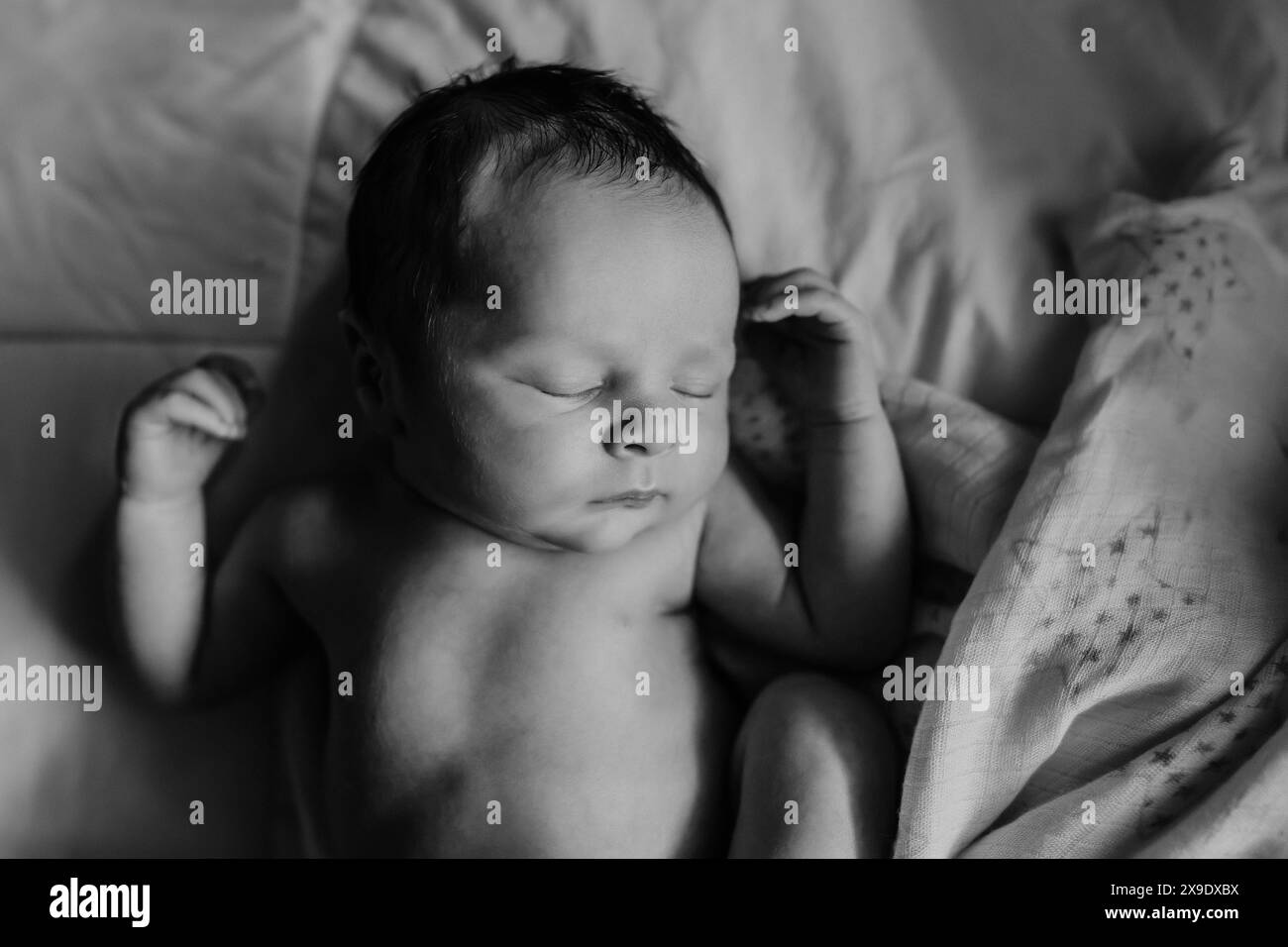 Schwarz-weiß-Bild des Jungen, der in wunderschönem Licht schläft Stockfoto