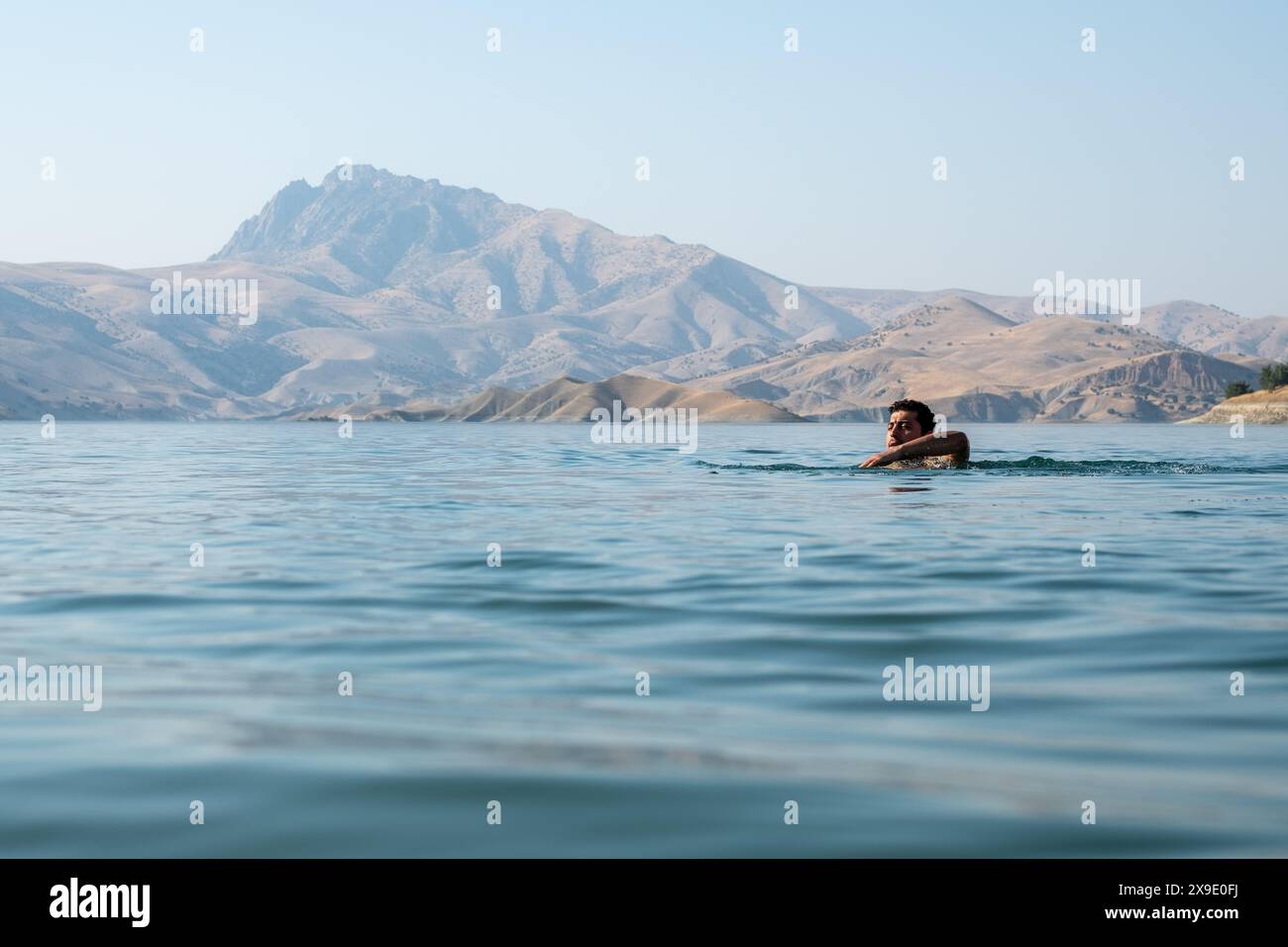 Mann schwimmt im See, Bergkulisse Kurdistan Irak Stockfoto