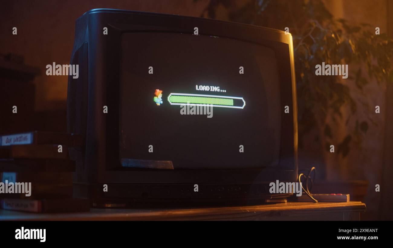 Nahaufnahme eines Retro-Fernsehbildschirms mit einem Acht-Bit-Videospiel mit Konsolen-Arcade-Videospiel. Quest wird geladen, Spieler wartet auf einen neuen härteren Level. Grüner Fortschrittsbalken Wird Bewegt. Stockfoto